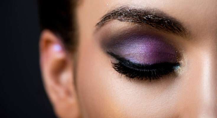 Consigli make-up occhi: trucco elegante con ombretto viola sfumato, accenti dorati e eyeliner nero per un look glamour da sera.